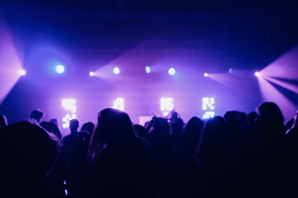 Crowd watching a stage lit in purple at a live event